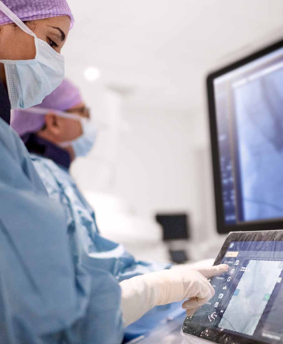 Clinician operating the table-side touchscreen in an interventional room